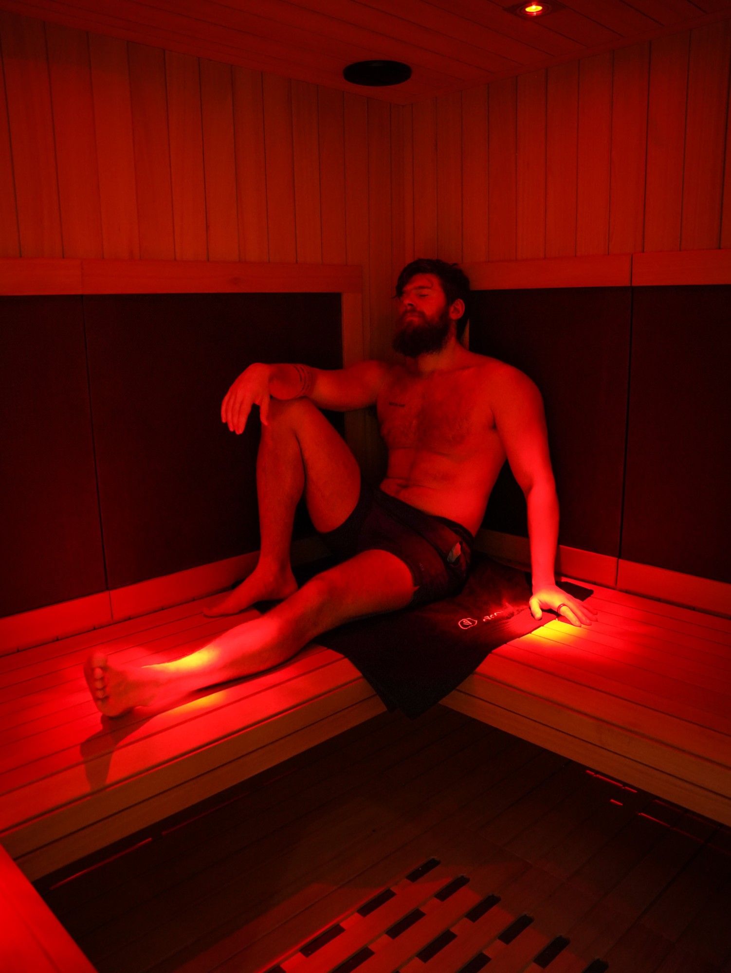 Klant rust in een infraroodcabine onder rood licht