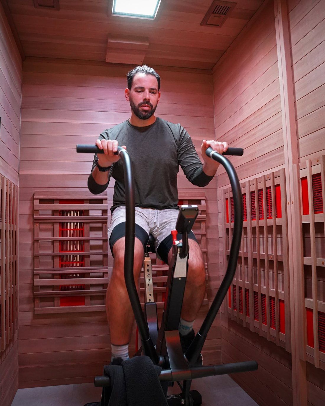Klant traint op een fiets in een infrarood-sportcabine